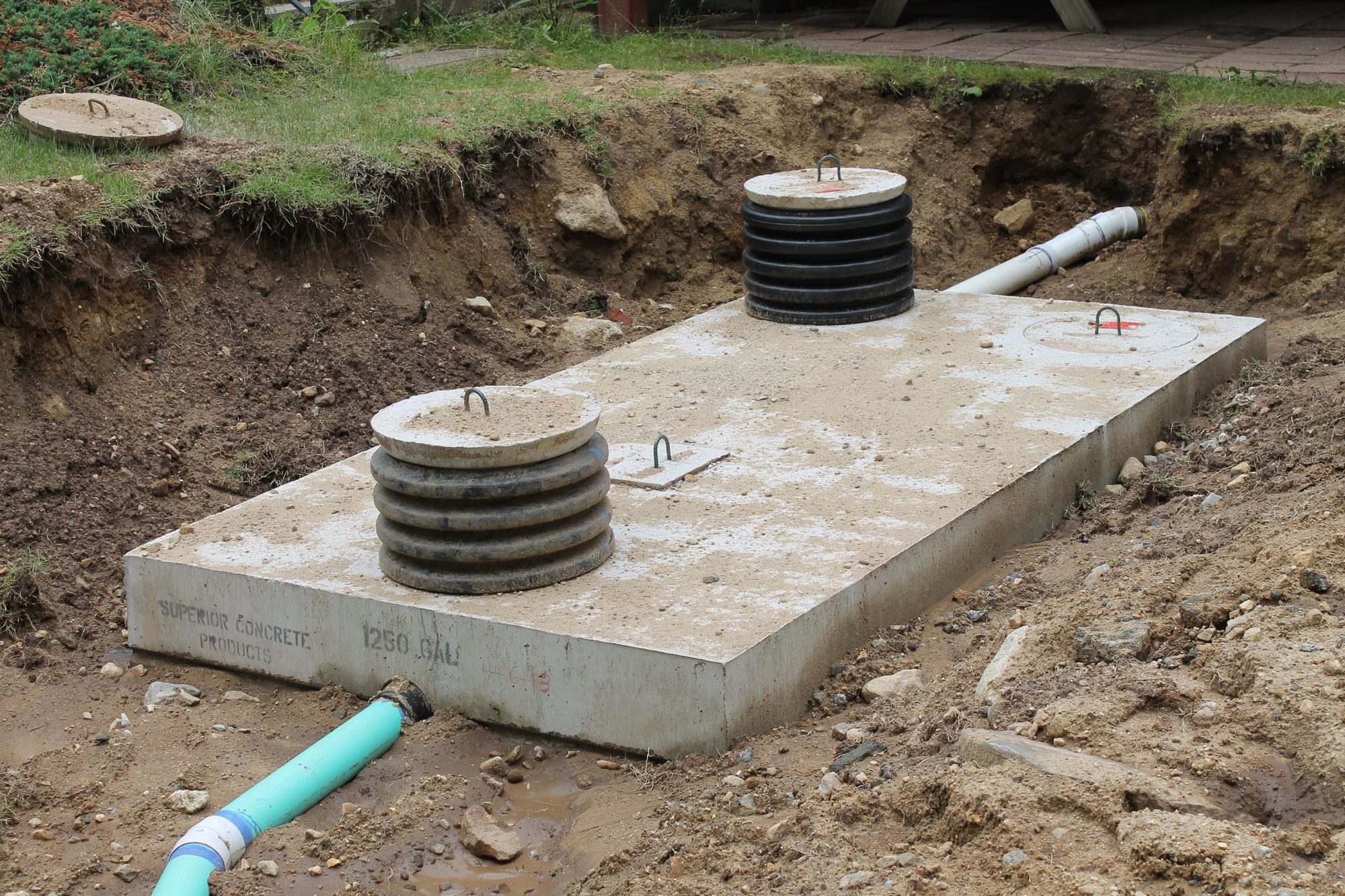 Image of a concrete septic tank with 2 risers awaiting backfill.