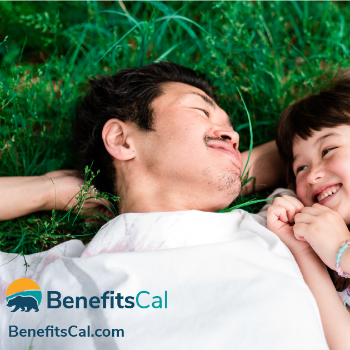father and daughter lying in the grass and smiling, text reads BenefitsCal www.BenefitsCal.com