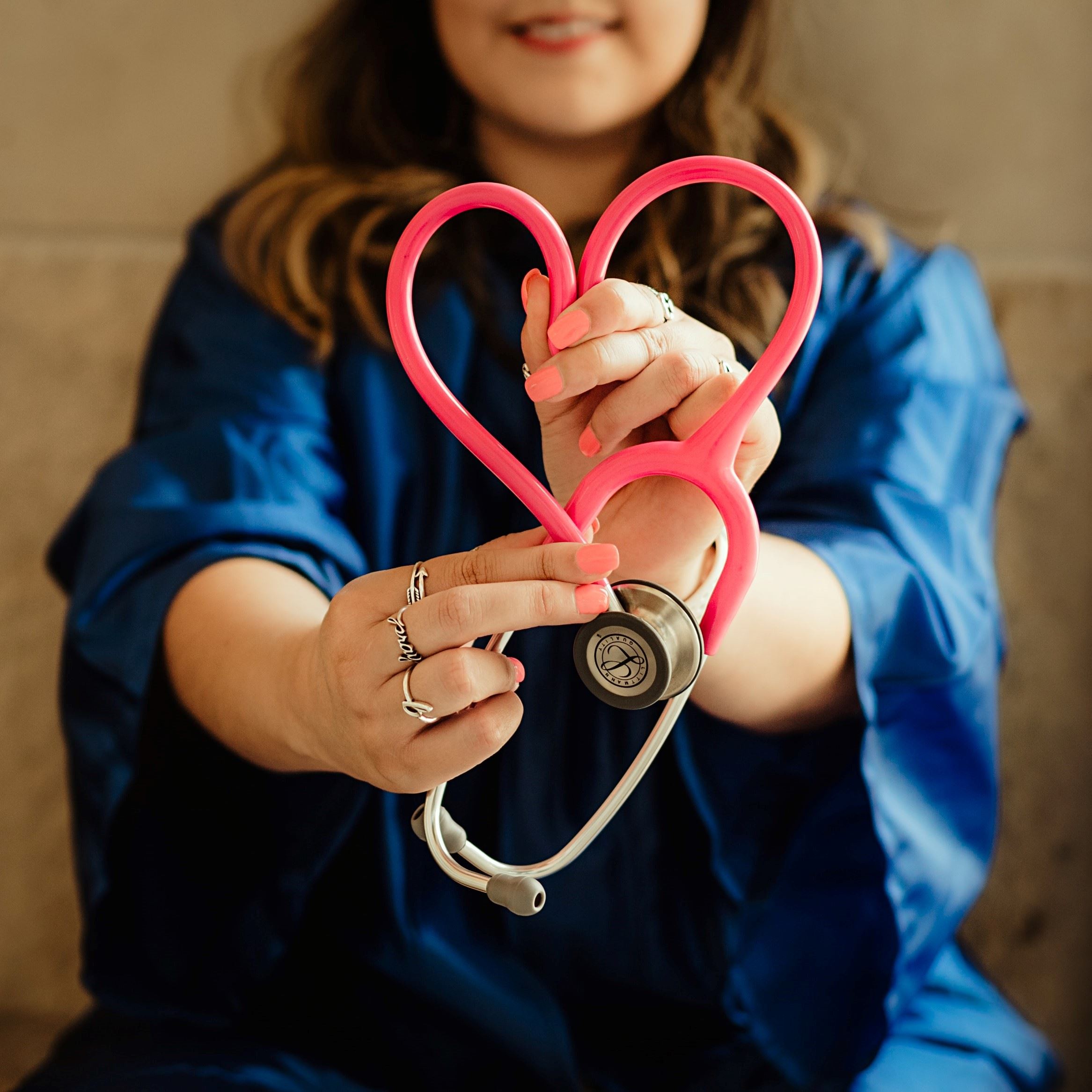 woman holding a stethoscope in the shape of a heart
