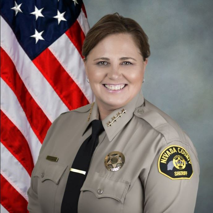 Sheriff Shannan Moon in uniform seated in front of an American flag