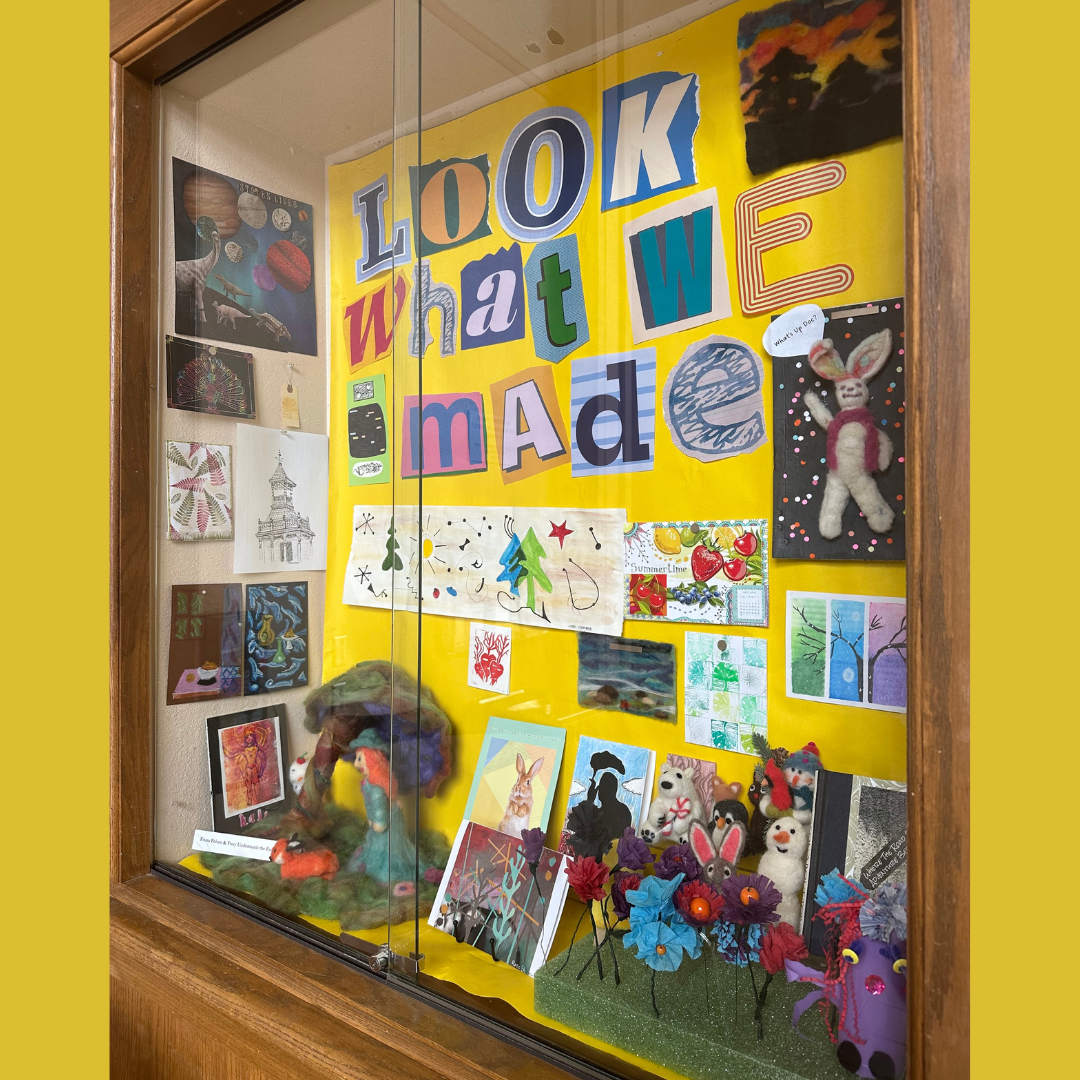 Picture of display case with art and felted crafts