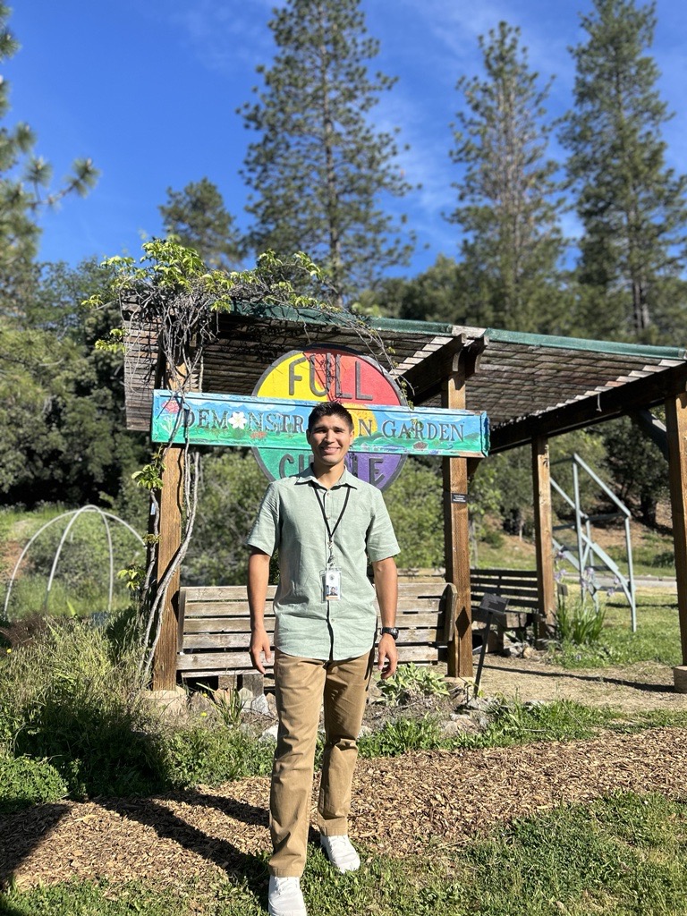 Daniel Amezola outside wearing sage green shirt and khaki pants