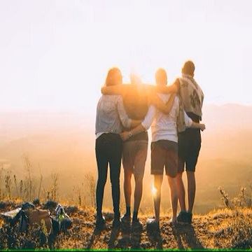 four people with their arms linked facing the sun. 