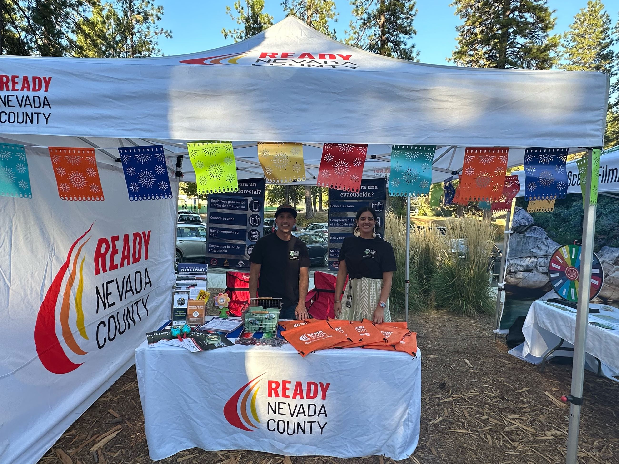 Latino Family Festival booth with two OES staff members 