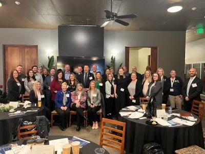 A large group of people in business attire pose for a group photo